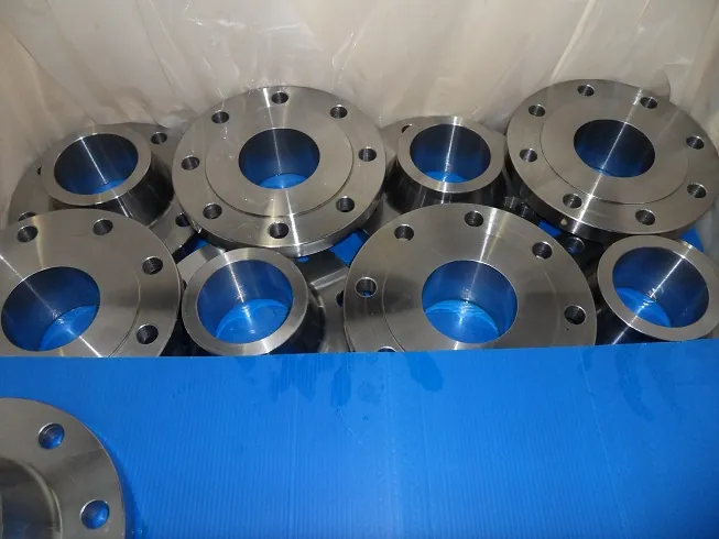 Machined weld neck and flat flanges packed tightly in a case lined with white plastic film