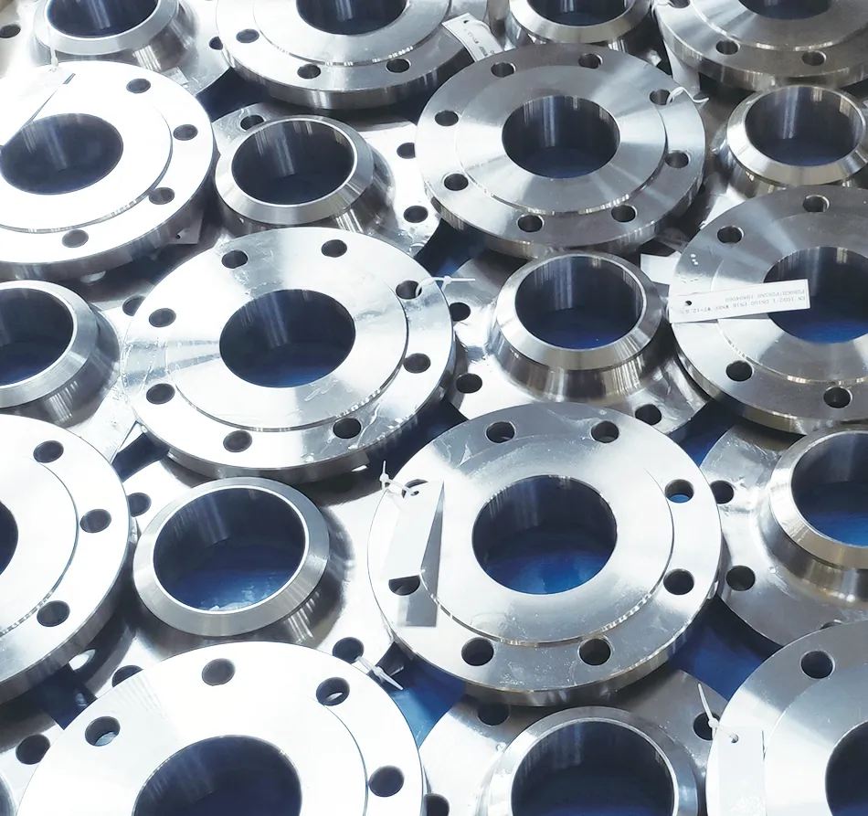 A heap of freshly machined weld neck flanges on a blue sheet; one carries a white tag printed with an EN 1092-1 designation