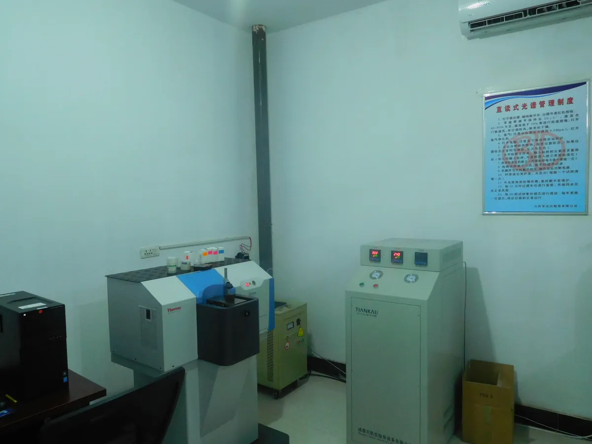 Light-blue lab room with a benchtop spark spectrometer and two instrument cabinets